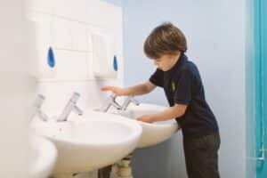 Schoolboy washing his hands