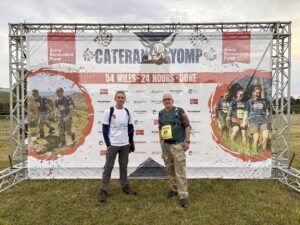 Castle Water employees Kevin and Peter standing in front of the 2025 Cateran Yomp event sign