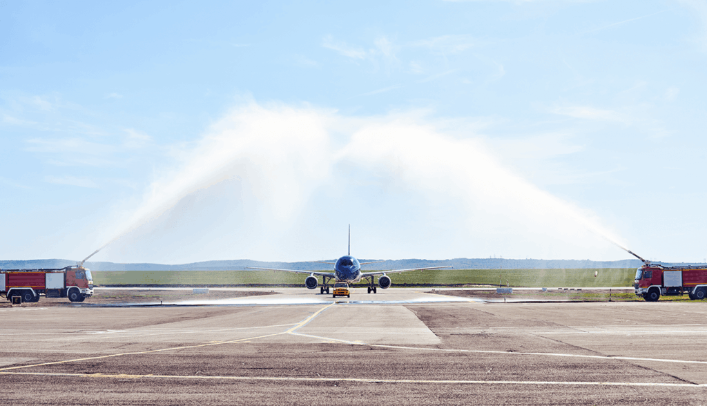 Fire engines at airport watering a plane